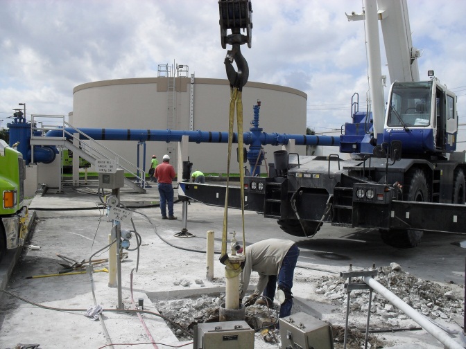 Plant maintenance personnel repair a monitoring well