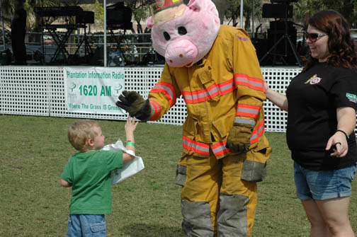 Fire dept mascot giving a child a high-five